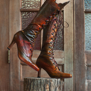 Embossed leather high leaf boots featuring intricate patterns, combining style and texture